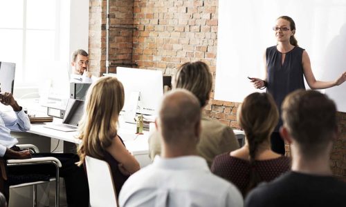 A group of managers attending a training session led by a woman